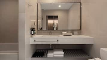 Een moderne badkamer met een grote spiegel, een wit wastafelmeubel en een handdoekhouder.