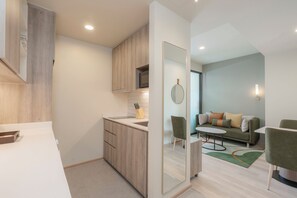 Une cuisine moderne avec des meubles en bois, un plan de travail blanc et un four à micro-ondes encastré.