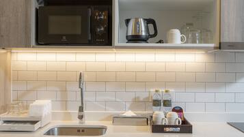 A modern kitchen with a microwave, kettle, and dishwasher.