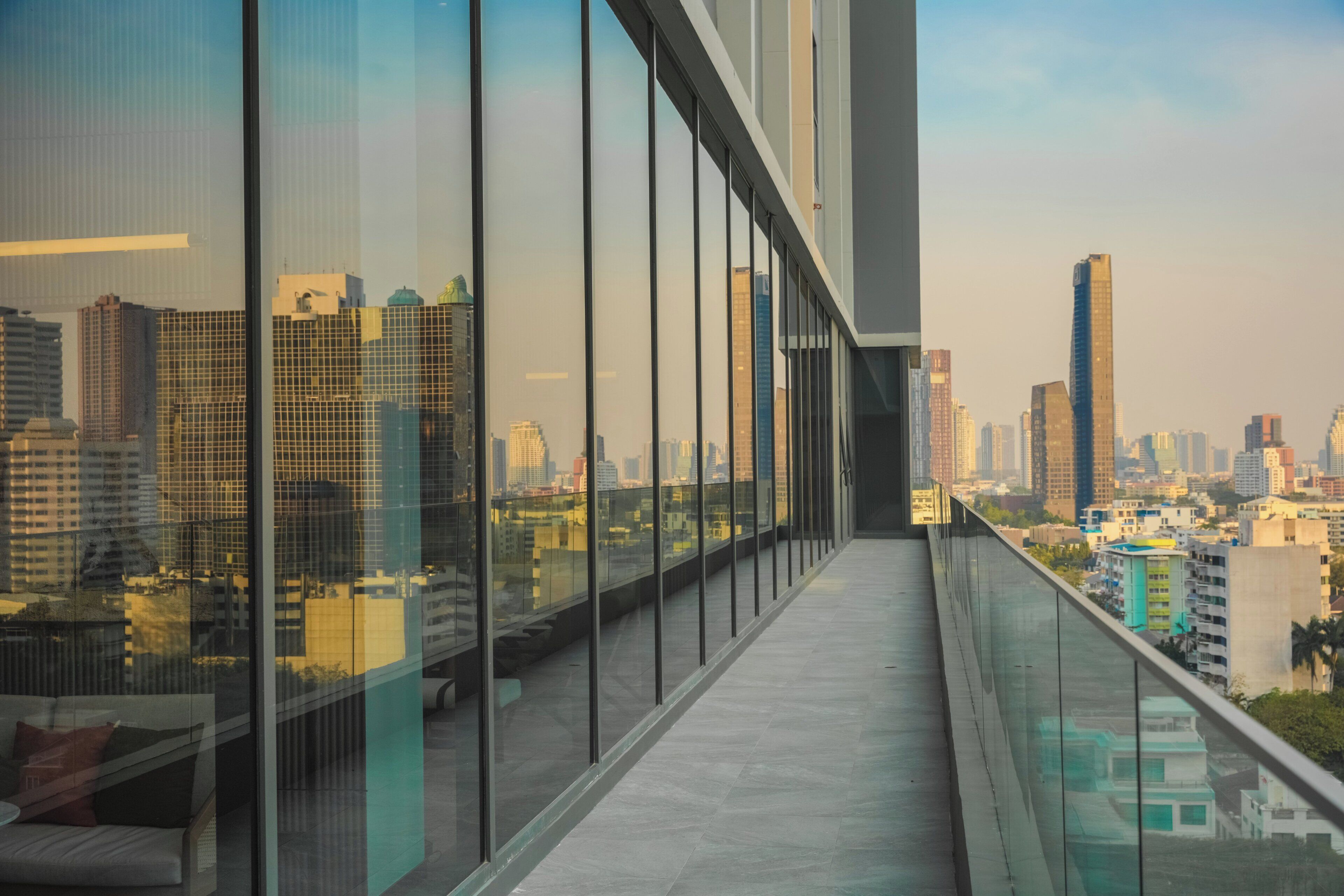 A high-rise building with a glass balcony overlooking a cityscape.