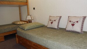 A bunk bed with two single beds below, each with a pillow and a lamp on a bedside table. - Cozy Studio 4 pers · Ski-in · Pets Allowed (Belle Plagne)