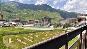 Eine gebirgige Landschaft mit Sportplatz, Gebäuden und einem Turm.