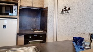 Eine kleine Küche mit Mikrowelle, Herd und Backofen.