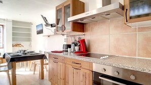Een moderne keuken met houten kastjes, een granieten aanrecht en roestvrijstalen apparatuur.