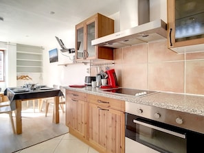 Eine moderne Küche mit Holzausstattung, einer Granit-Arbeitsplatte und Edelstahlgeräten.