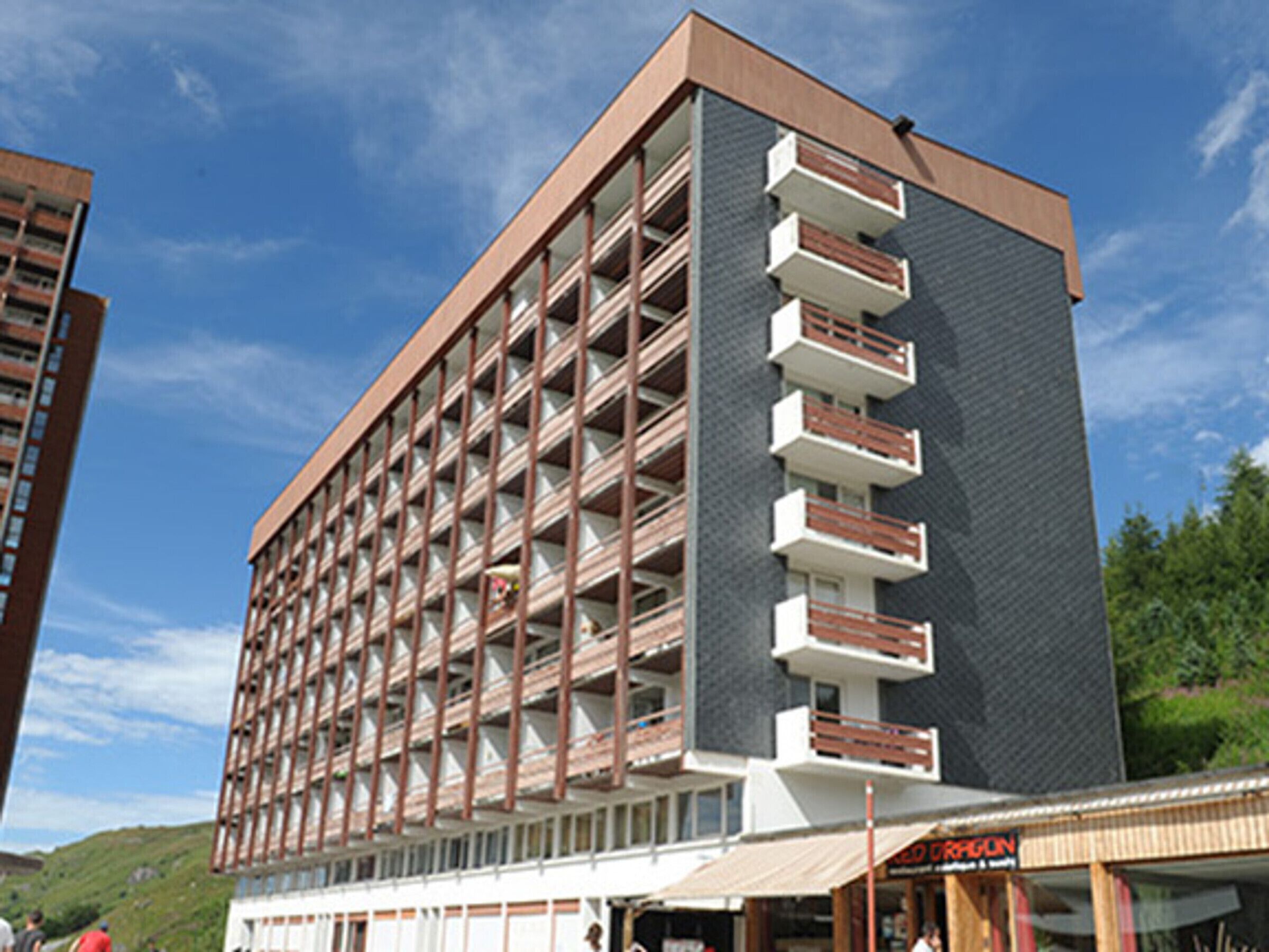Ein mehrgeschossiges Hotel mit modernem Design, das Balkone in jeder Etage bietet.