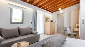 A modern bedroom with a sofa, a bed, a wooden cabinet, and a desk. - Metropolitan Pearl Hotel (Chania)