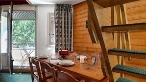 A wooden dining table with chairs, a red pot, and a candle. - Charming duplex 6 pers, near slopes, north balcony, WiFi (Les Menuires)