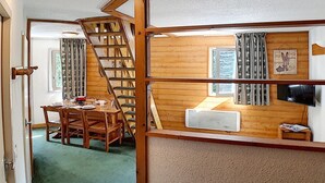 A room with a wooden staircase, a dining area with a table and chairs, and a television on a wooden shelf. - Charming duplex 6 pers, near slopes, north balcony, WiFi (Les Menuires)