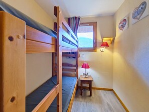 Habitación con literas, una mesita y una lámpara.