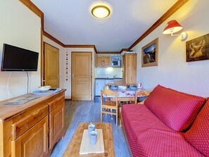 A compact living space with a kitchenette, a dining area, and a sofa.