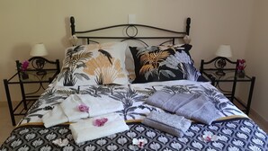 A neatly made bed with floral-patterned bedding, two pillows, and a set of towels. - 2 steps from the historic center, gite*** with beautiful saltwater swimming pool (Sarlat-la-Canéda)