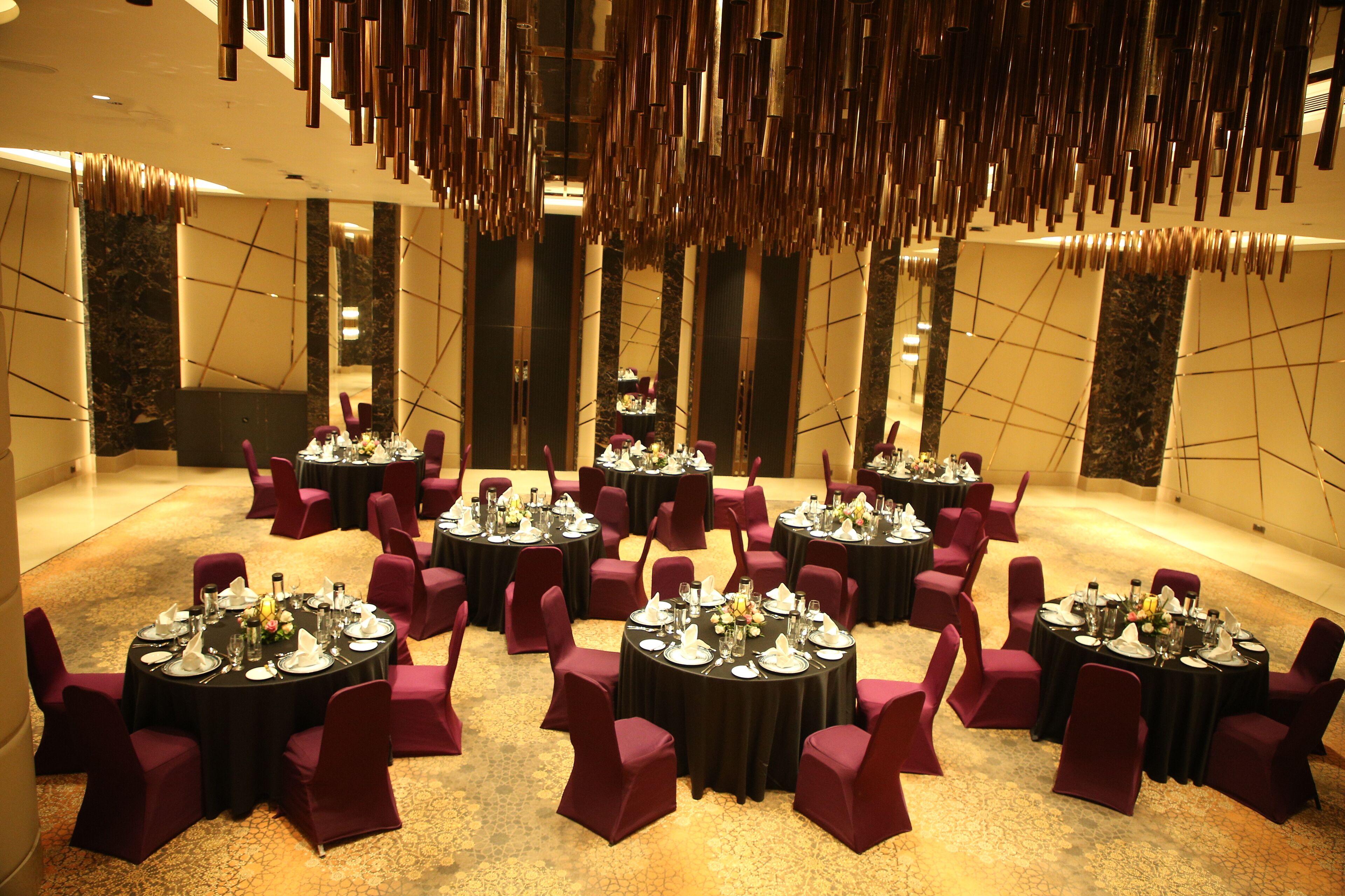 A conference room with multiple round tables, each set with chairs and tableware.