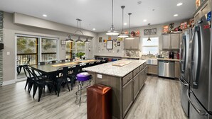 A modern kitchen with a central island, stainless steel appliances, and pendant lighting. - Private Basketball Court/Hot Tub-Community Pools (Branson)