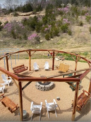 Relax in a serene outdoor seating area with a pergola, comfortable chairs, and a cozy fire pit.