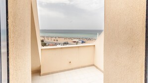 Een balkon met uitzicht op een strand en de zee.