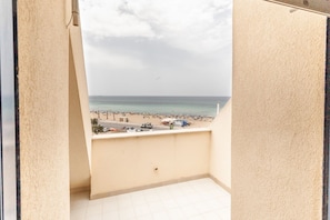 Un balcon avec vue sur une plage et la mer.