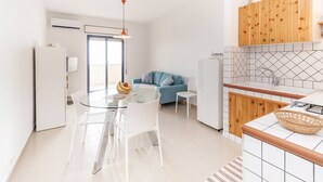 Een moderne keuken met een eethoek, een blauwe bank en een houten kast.