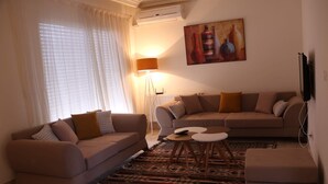 Un salon avec deux canapés, une table basse et un tapis à motifs.