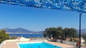 A swimming pool with a view of the sea and mountains.