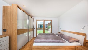 Une chambre à coucher avec un lit en bois, une table de chevet et une armoire.