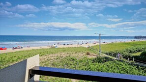 A beach with people, umbrellas, and a pier in the background. - Oceanview Oasis by Bayley Vacation Rentals (Old Orchard Beach)