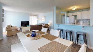 A modern living room with a dining area, a kitchen, and a TV in the living room. - Oceanview Oasis by Bayley Vacation Rentals (Old Orchard Beach)