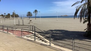 A beach with palm trees, a clear sky, and a distant rocky outcrop. - Holiday Home "Los Almendros" with Shared Pool, Terrace & Wi-Fi (Vera)