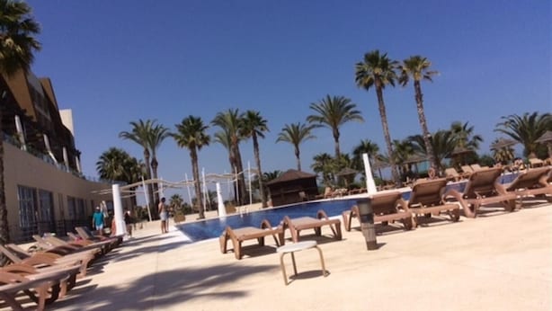 A pool area with lounge chairs, palm trees, and a clear blue sky. - Holiday Home "Los Almendros" with Shared Pool, Terrace & Wi-Fi (Vera)