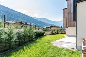 Un quartier résidentiel avec des maisons, une pelouse verdoyante et des montagnes en arrière-plan.