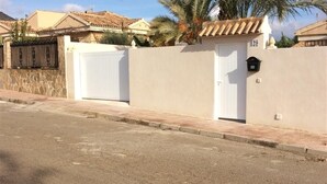 A street view with a gated entrance, a white door, and a mailbox. - Pet-Friendly Villa Casa Cuesta with Pool & Garden (Bolnuevo)