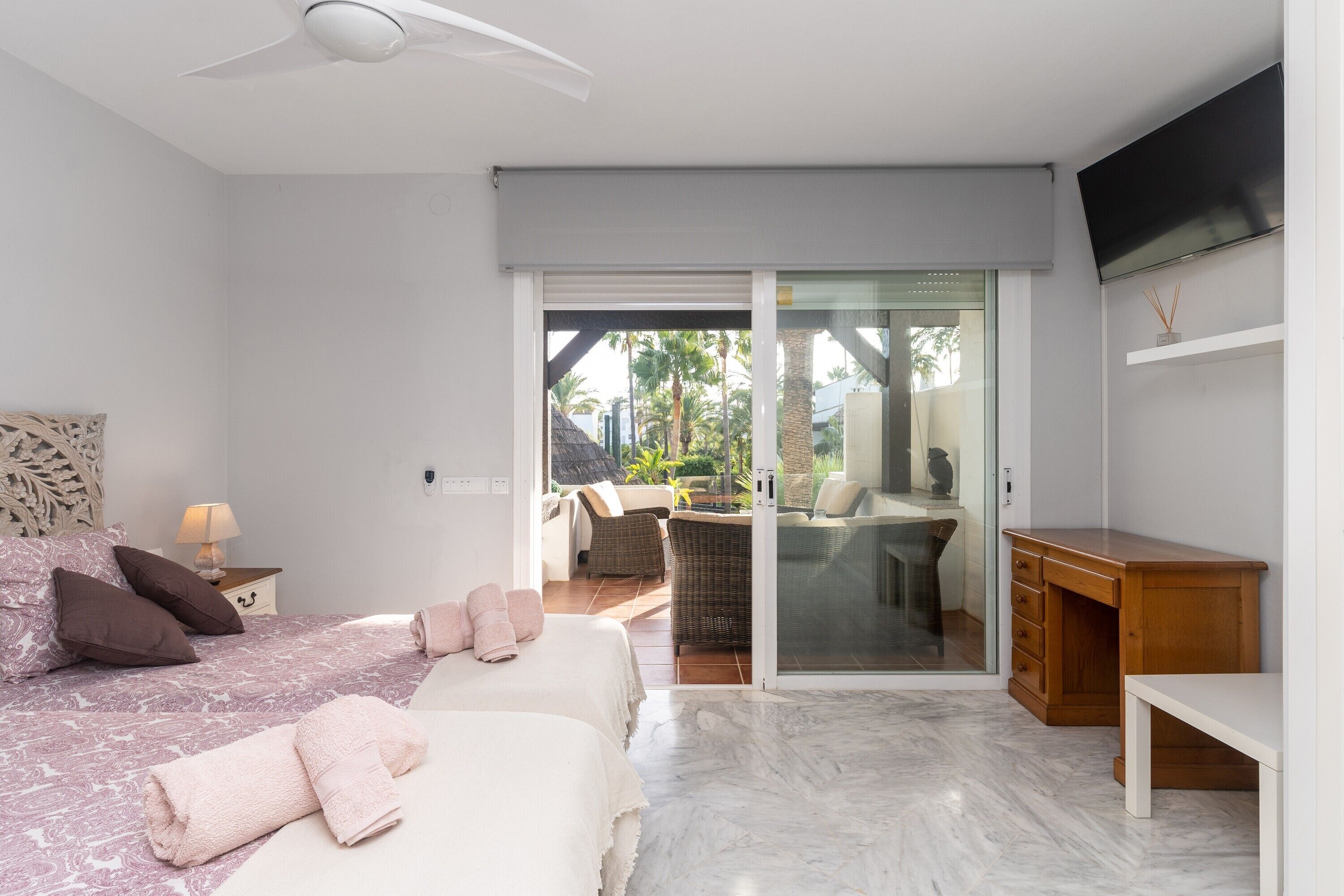 Un dormitorio con cama, escritorio, silla y televisor.
