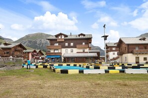 A mountain resort with wooden buildings, a pool area, and a view of the mountains.