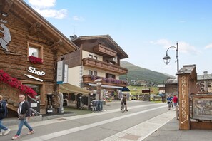 A wooden building with a shop sign, a sign for a chalet decor shop, and a street with pedestrians.