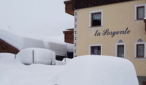 Un edificio con el letrero 'la Sorgente' y alrededores cubiertos de nieve.