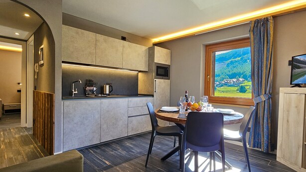 Una cocina moderna con comedor, televisor y vistas panorámicas.