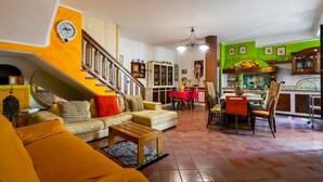 A living room with a sofa, coffee table, and a staircase leading to an upper floor.