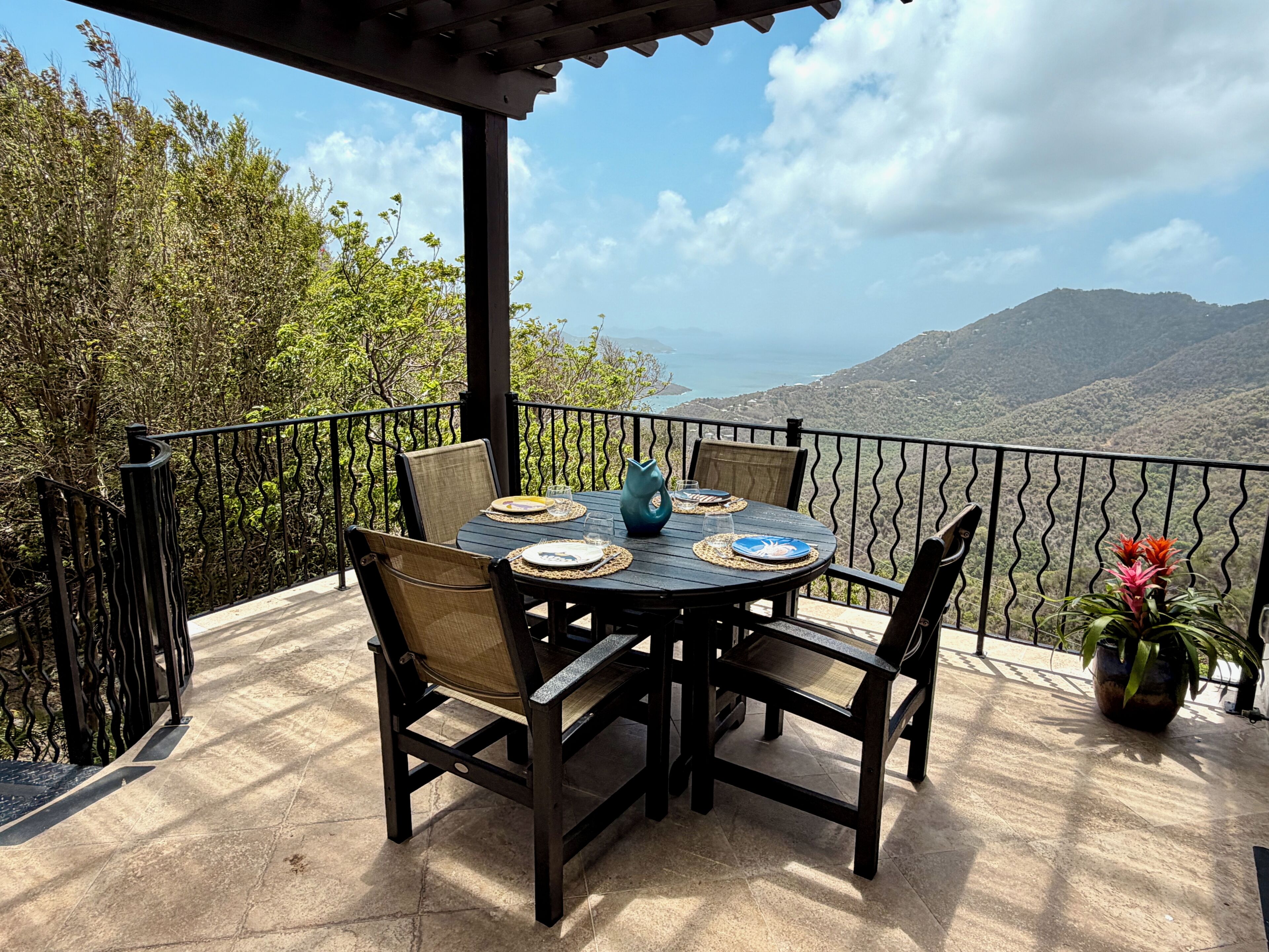 Una mesa redonda con sillas y vistas a montañas.