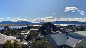 Ein Wohngebiet mit Häusern, blauem Himmel und Bergen im Hintergrund.