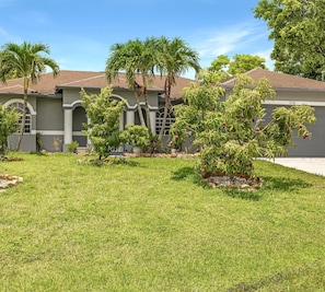 Enjoy a serene retreat in a beautifully maintained home with a lush green lawn and mature trees.