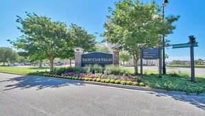 Un panneau indiquant l’emplacement de Yacht Club Villas, avec des indications pour se rendre à la marina, aux quais d’embarquement et de débarquement, et à Barefoot Queen.