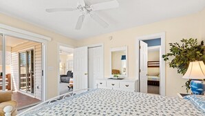 A bedroom with a bed, dresser, and a ceiling fan. - Spacious cottage close to the beach with an outdoor pool.  OGC 9632 (Myrtle Beach)