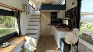 A modern interior with a kitchen, dining area, and staircase. - ALBIZIA BOUTIQUE HOTEL (Ula)