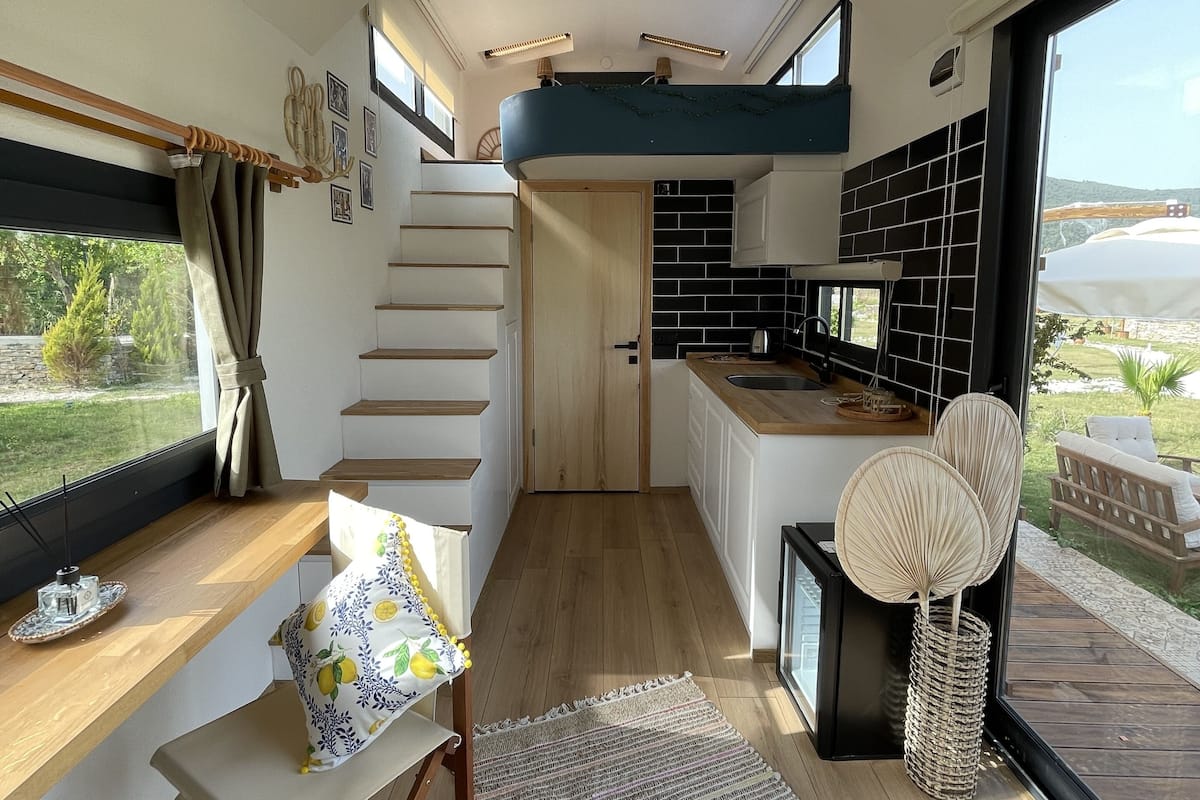 A modern interior with a kitchen, dining area, and staircase.