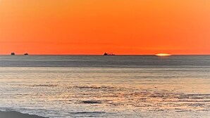 A sunset over a calm sea with a distant ship. - Panoramic Water Views, Retro Vibe, EV Charger, (Port Angeles)