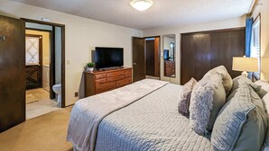 A bedroom with a bed, dresser, TV, and a mirror. - Panoramic Water Views, Retro Vibe, EV Charger, (Port Angeles)
