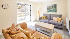 A living room with a sofa, a coffee table, and a clock on the wall. - Host & Stay | Foggyshaw Lodge (Middlesmoor)