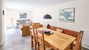 A dining area with a wooden table and chairs, a pendant light, and a painting on the wall. - Host & Stay | Foggyshaw Lodge (Middlesmoor)