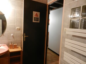 Ein Hotelzimmer mit einer schwarzen Tür, einem Spiegel, einem Waschbecken und einer Toilette.