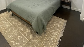 A bedroom with a bed, a nightstand, a ceiling fan, and framed artwork on the wall. - Cozy 2 Bed (Sterling)